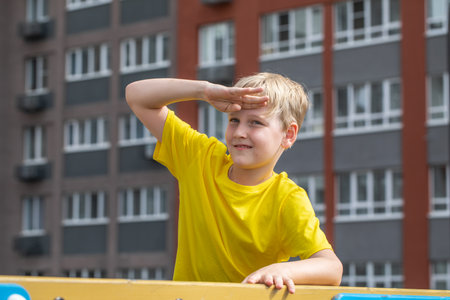 Close-up portrait of a little boy wearing a yellow t-shirtの写真素材