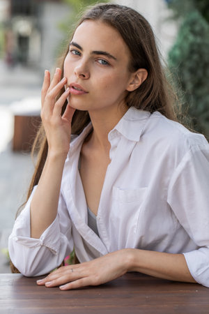 Business portrait of a young beautiful woman in white shirt