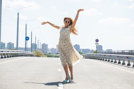 Portrait of a young beautiful woman walking in white summer dressの写真素材