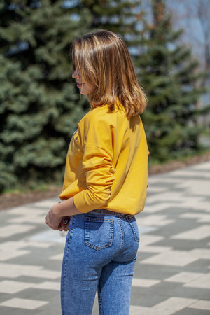 Back view, portrait of a young beautiful woman in blue jeansの写真素材