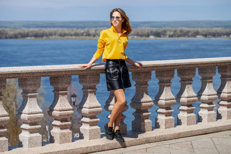 Full body portrait of a young beautiful woman in yellow long sleeve blouseの写真素材