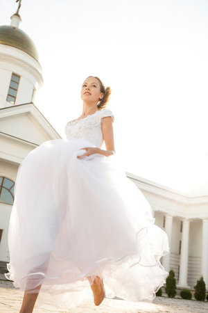 Full length portrait of a young woman in a white ball gownの写真素材