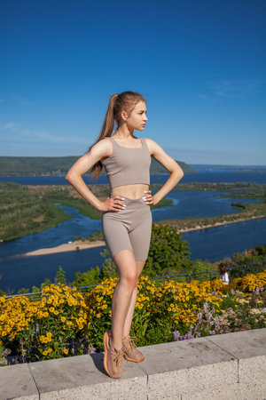 Fitness portrait young athletic woman doing on blue sky backgroundの写真素材