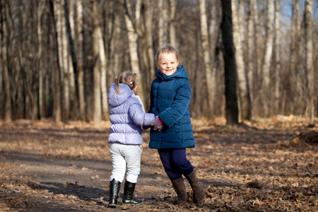 Sisters in autumn parkの写真素材