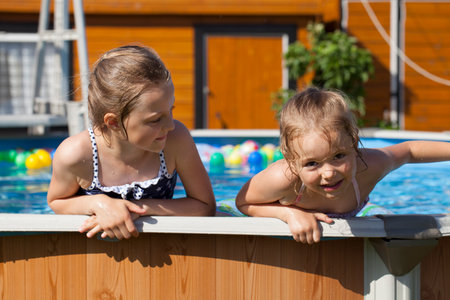 Happy little Girl in bikini swimming pool, summer outdoorsの写真素材