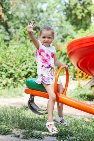 Little girl posing on playground in summer yardの写真素材