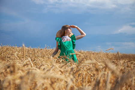 Portrait of a young beautiful blonde woman posing in a wheat fieldの写真素材