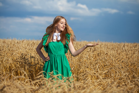 Portrait of a young beautiful blonde woman posing in a wheat fieldの写真素材