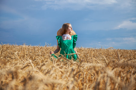 Portrait of a young beautiful blonde woman posing in a wheat fieldの写真素材