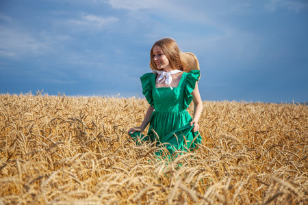 Portrait of a young beautiful blonde woman posing in a wheat fieldの写真素材