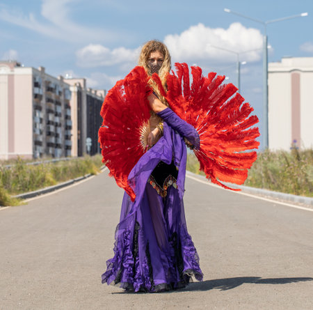 Eastern dance. Young beautiful woman in a purple costume dances on the streetの写真素材