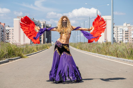 Eastern dance. Young woman in a purple costume dances on the streetの写真素材