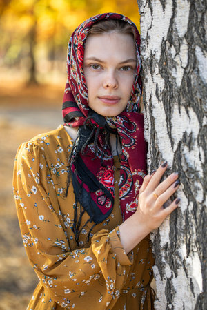 Portrait of a young beautiful girl with a scarf on her headの写真素材