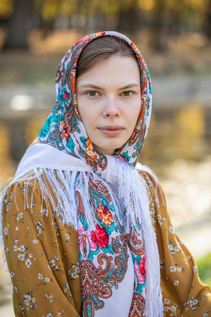 Portrait of a young beautiful girl with a scarf on her headの写真素材