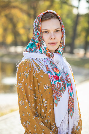 Portrait of a young beautiful girl with a scarf on her headの写真素材