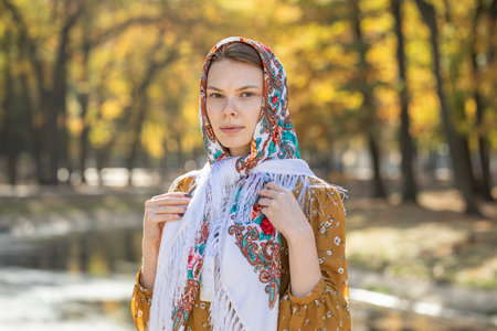 Portrait of a young beautiful girl with a scarf on her headの写真素材