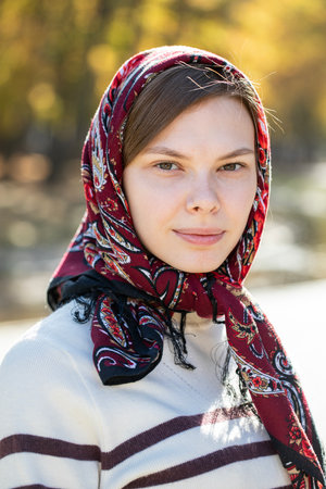Portrait of a young beautiful girl with a scarf on her headの写真素材