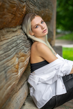Close up portrait of a young blonde woman against the background of an old wooden wallの写真素材