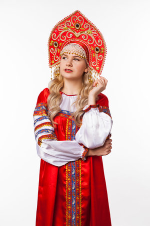 Traditional Russian folk costume, portrait of a young beautiful blonde girl in red dress, isolated on white backgroundの写真素材