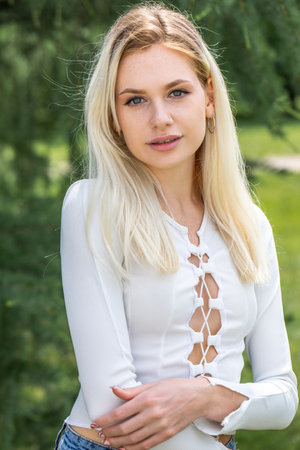 Young beautiful blonde girl posing in summer parkの写真素材