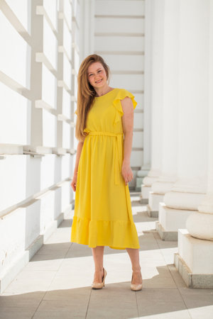 Full body portrait of a red-haired woman in yellow dressの写真素材