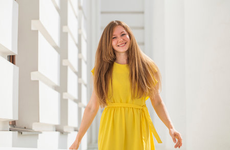 Happy portrait of a red-haired woman in yellow dressの写真素材