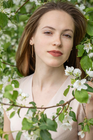 Young beautiful girl posing in a blooming gardenの写真素材