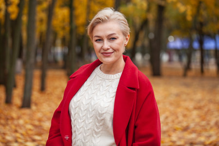 Autumn portrait of a middle aged woman in a red coatの写真素材