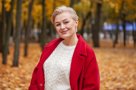 Autumn portrait of a middle aged woman in a red coatの写真素材