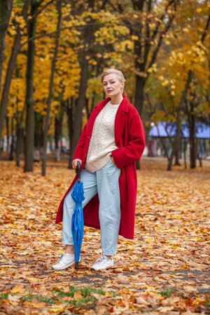 Autumn portrait of a middle aged woman in a red coatの写真素材