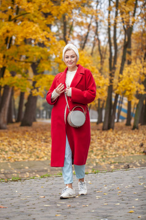 Autumn portrait of a middle aged woman in a red coatの写真素材