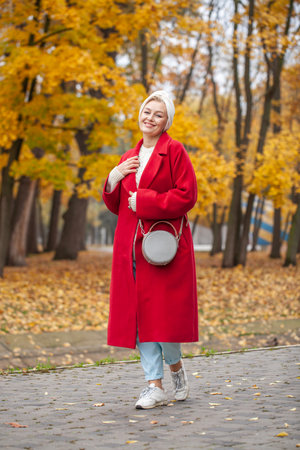 Autumn portrait of a middle aged woman in a red coatの写真素材