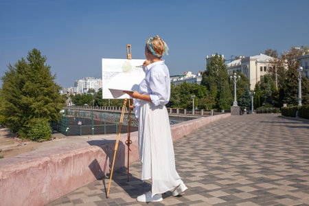 Female artist paints a cityscape in Samaraの写真素材