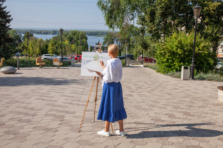Female artist paints a cityscape in Samaraの写真素材