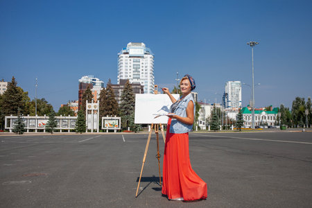 Female artist paints a cityscape in Samaraの写真素材