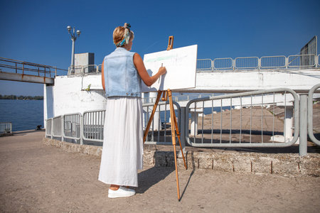 Female artist paints a cityscape in Samaraの写真素材