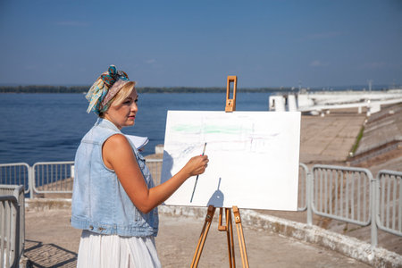 Female artist paints a cityscape in Samaraの写真素材