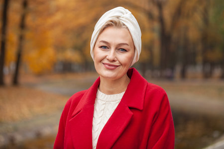Autumn portrait of a middle aged woman in a red coatの写真素材