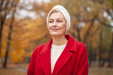 Autumn portrait of a middle aged woman in a red coatの写真素材