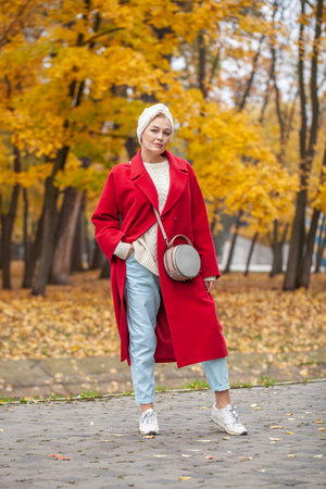 Autumn portrait of a middle aged woman in a red coatの写真素材