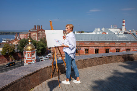 Female artist paints a cityscape in Samaraの写真素材