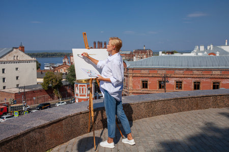 Female artist paints a cityscape in Samaraの写真素材