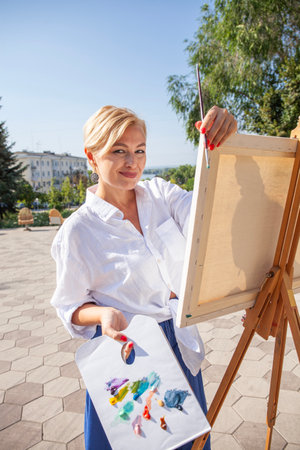 Female artist paints a cityscape in Samaraの写真素材