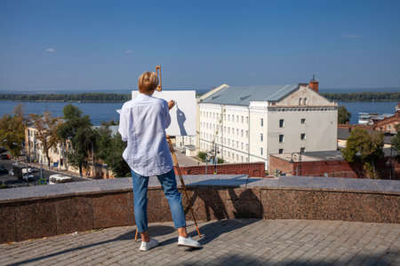 Female artist paints a cityscape in Samaraの写真素材