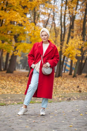 Autumn portrait of a middle aged woman in a red coatの写真素材