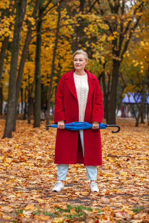 Autumn portrait of a middle aged woman in a red coatの写真素材