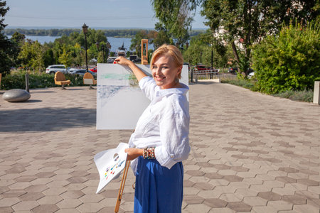 Female artist paints a cityscape in Samaraの写真素材