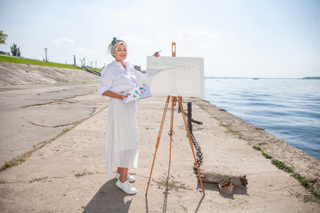 Female artist paints a cityscape in Samaraの写真素材