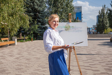 Female artist paints a cityscape in Samaraの写真素材