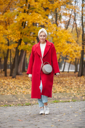 Autumn portrait of a middle aged woman in a red coatの写真素材